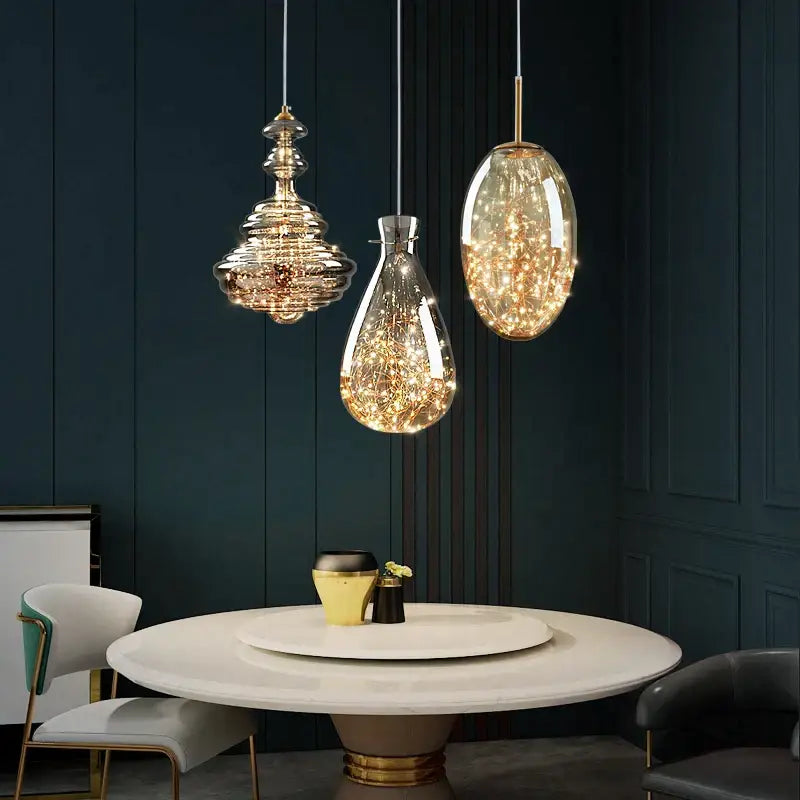 Three elegant glass pendant lights with golden accents and fairy lights in a decorbites crystal chandelier for dining room
