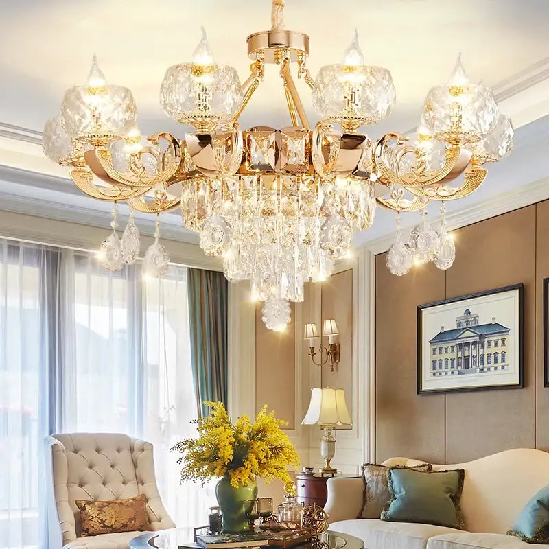 Gold-toned decorbites crystal chandelier with ornate detailing and faceted glass pendants for grand european interiors