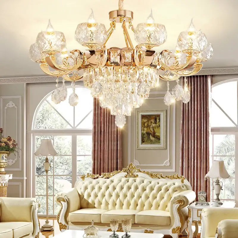 Gold-toned decorbites crystal chandelier with ornate detailing and crystal droplets for grand european villa use