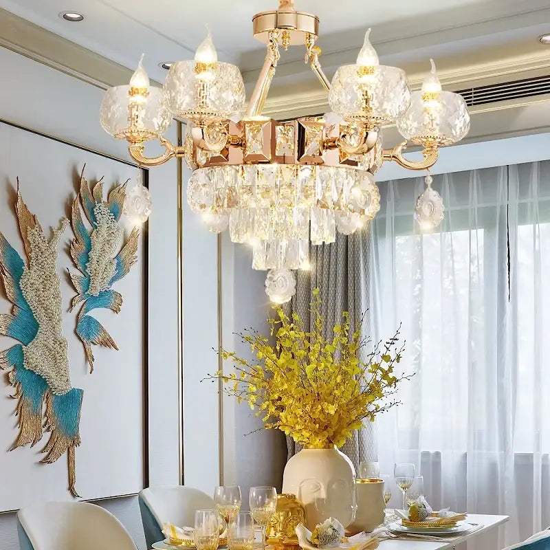 A luxurious gold-toned decorbites crystal chandelier with crystal droplets and candle-style bulbs for elegant interiors