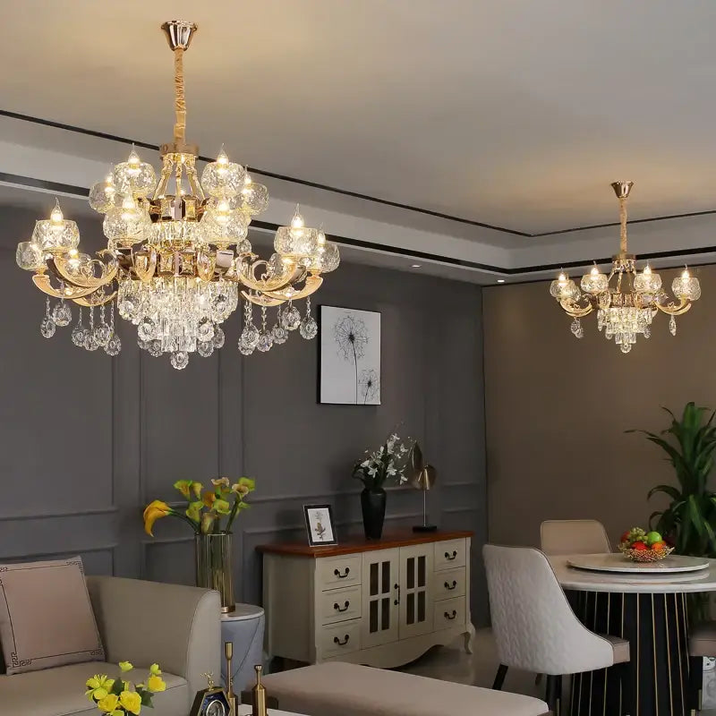 Gold-toned decorbites crystal chandelier with multiple crystal droplets and ornate arms for grand european interiors