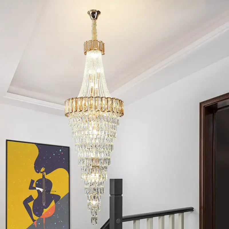 A multi-tiered decorbites crystal chandelier with gold-toned metal accents and cascading clear glass prisms for luxury spaces