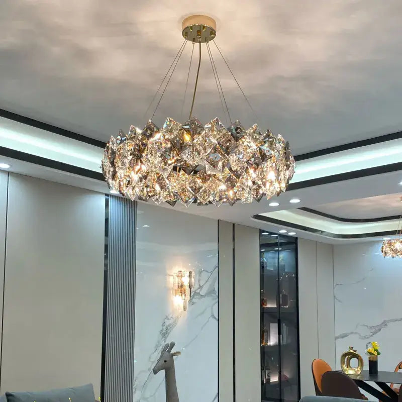 A modern decorbites crystal chandelier featuring faceted crystals in a circular design with a brass-toned fixture