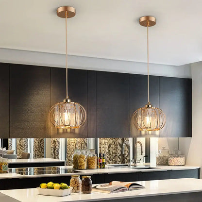 Two elegant gold-toned spherical cage pendant light fixtures with warm glow from DecorBites™ for modern décor