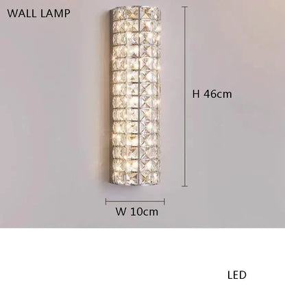 A tall slender decorbites crystal chandelier wall lamp with clear crystal facets for elegant dining room lighting
