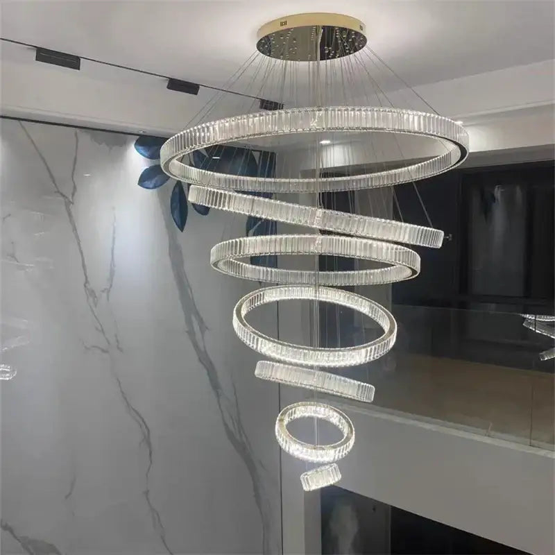 A modern decorbites crystal chandelier with faceted crystal rings and gold-toned mount for stairs lighting