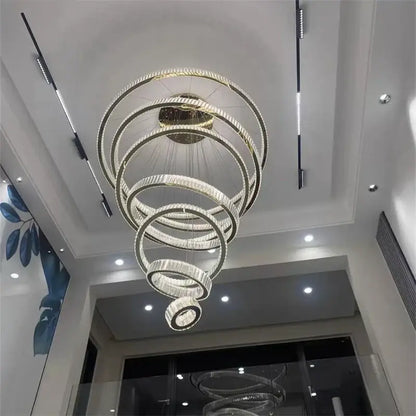 A modern decorbites crystal chandelier with concentric rings, clear crystals, and polished gold finish LED pendant light