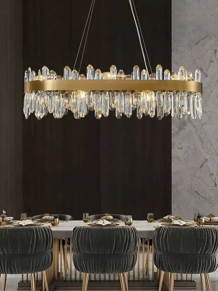 A luxurious gold-toned DecorBites crystal chandelier LED with cascading prisms hangs above a dining room table