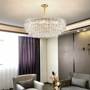 A decorbites crystal chandelier with a gold-toned fixture and clear glass prisms for modern luxury lighting
