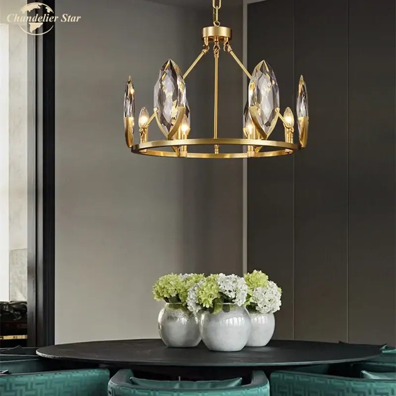 Gold-toned decorbites crystal chandelier with faceted crystal droplets and candle-style bulbs for luxurious living spaces