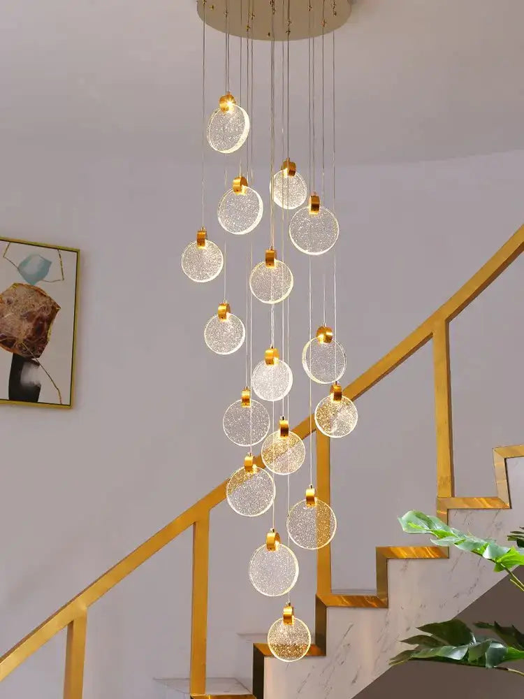 A DecorBites crystal chandelier LED pendant light with clear textured glass globes and gold chains for modern staircases