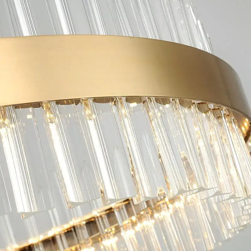 Gold-toned DecorBites crystal chandelier led with clear vertical crystal prisms on a sleek metallic ring for dining room