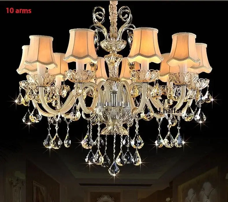 Decorbites crystal chandelier light featuring 10 gold-toned arms with crystal droplets and beige lampshades for luxury living