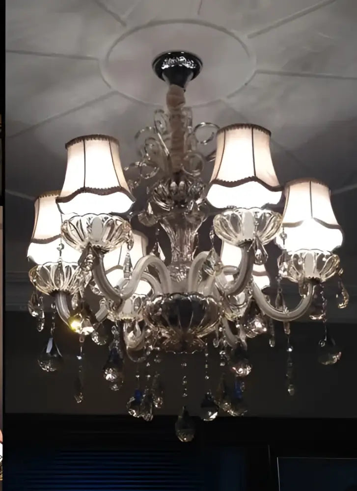 An ornate DecorBites crystal chandelier light with cream lampshades and teardrop crystals for modern luxury living