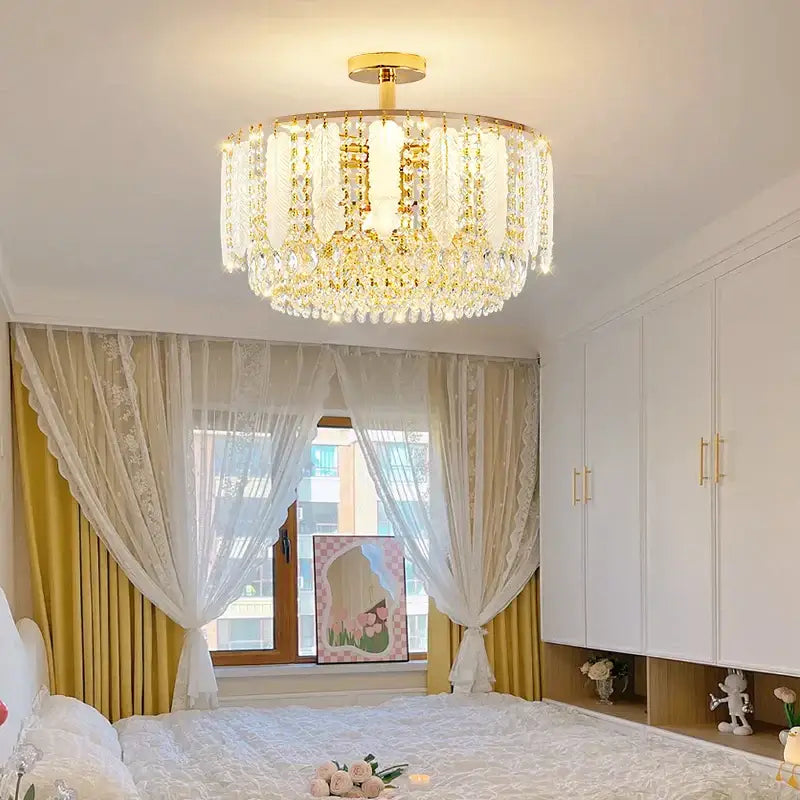 Gold-finished decorbites crystal chandelier light with cascading clear crystal droplets and central illumination for elegant decor