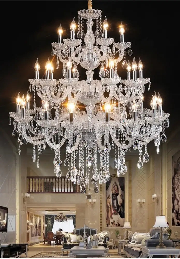 A multi-tiered decorbites crystal chandelier light with lit bulbs and teardrop crystals for luxury living spaces