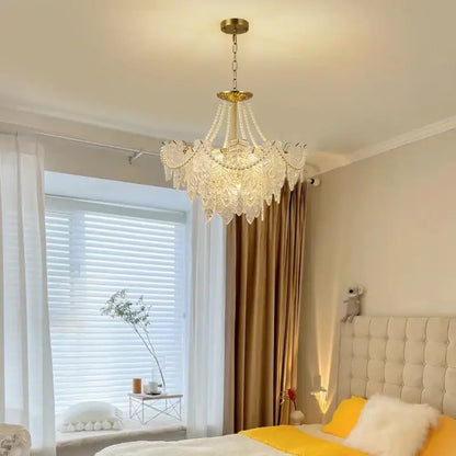 A delicate multi-tiered DecorBites crystal chandelier light with a gold-toned metal frame for living room use