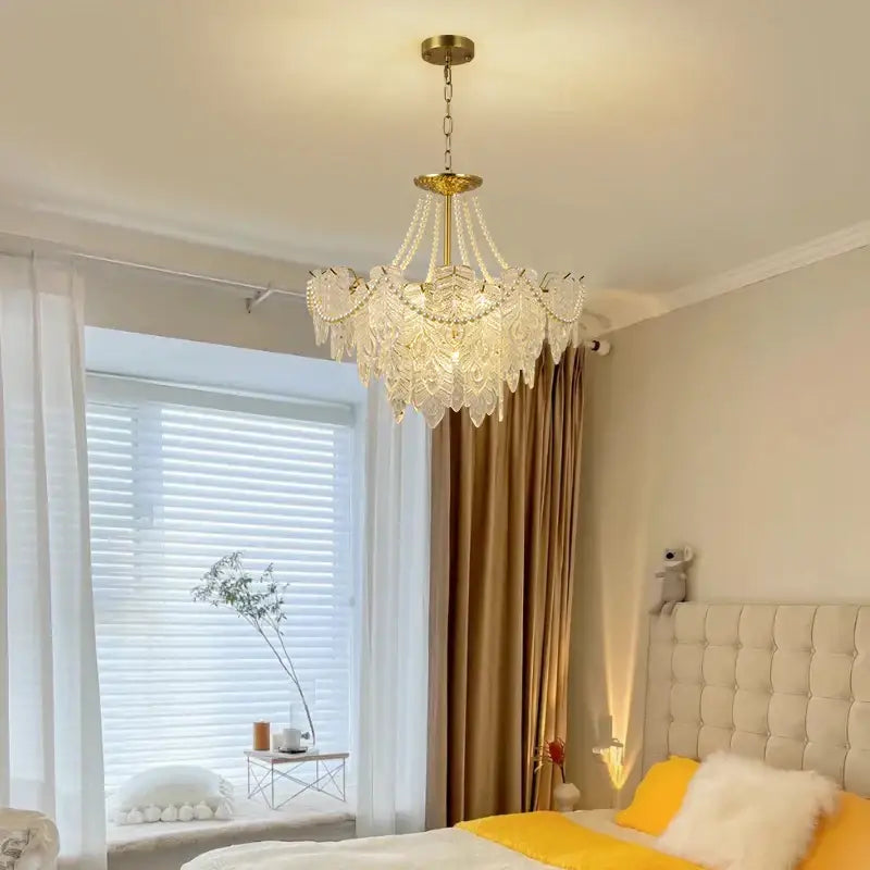 A delicate multi-tiered DecorBites crystal chandelier light with a gold-toned metal frame for living room use