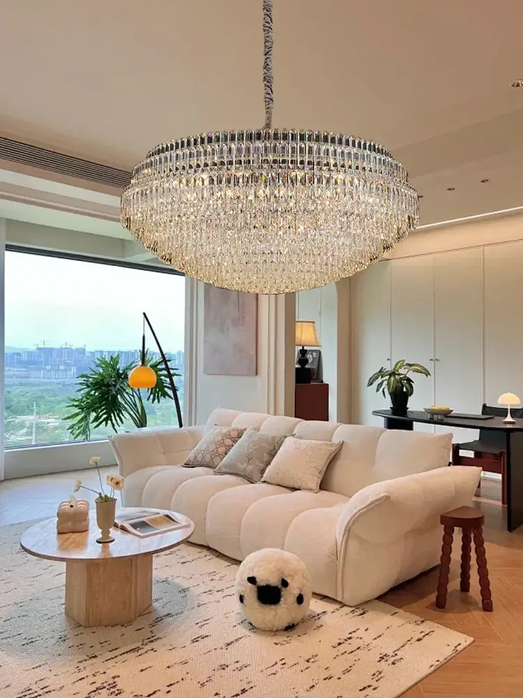 A large decorbites crystal chandelier featuring clear crystal prisms in concentric rings with metallic chain suspension