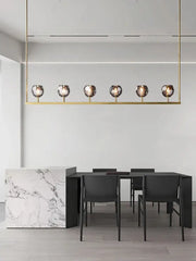 Gold-toned linear pendant crystal chandelier lights with six faceted glass globe bulbs for modern kitchen island decor