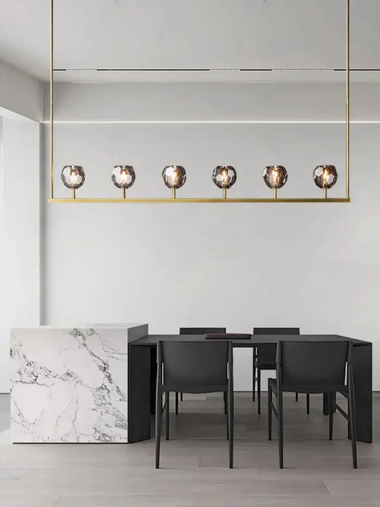 Gold-toned linear pendant crystal chandelier lights with six faceted glass globe bulbs for modern kitchen island decor