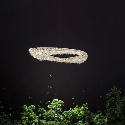 A decorbites crystal chandelier luminaire featuring a sparkling oval design with clear crystals and dangling droplets