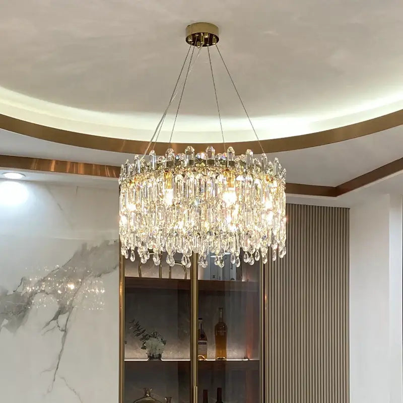 Decorbites crystal chandelier with gold-toned mount and cascading clear glass prisms for luxe LED living room decor