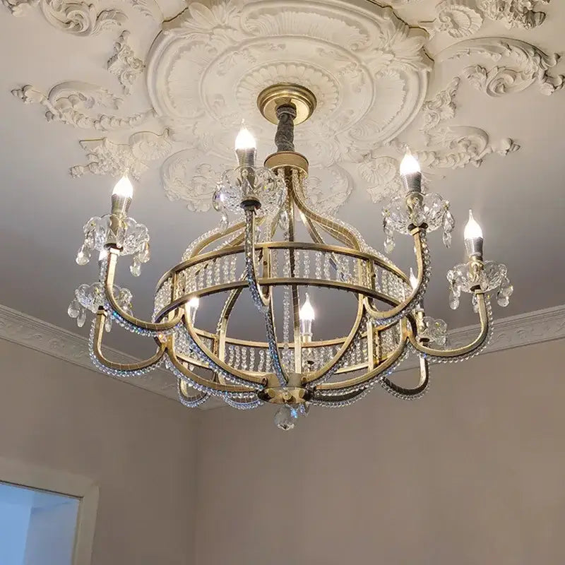 A gold-toned decorbites crystal chandelier pendant light with crystal droplets and ornate arms for luxe nordic interiors