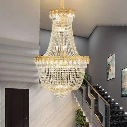 Decorbites crystal chandelier with multi-tiered clear crystals and gold-toned metal accents for duplex hotel stairwell
