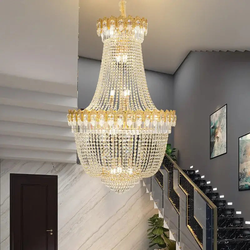 Decorbites crystal chandelier with multi-tiered clear crystals and gold-toned metal accents for duplex hotel stairwell