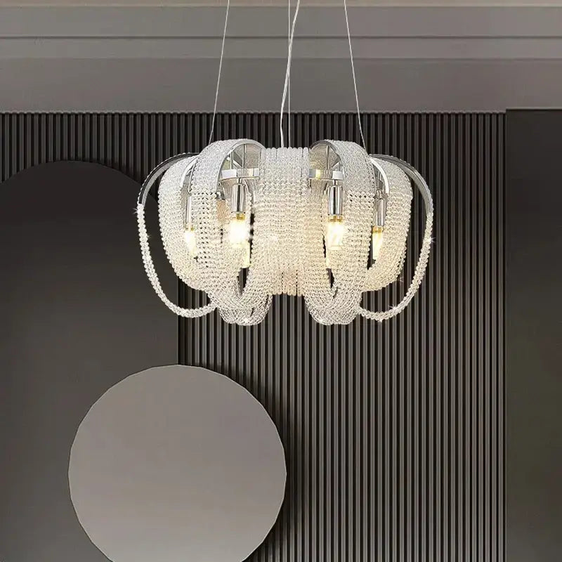 A decorbites crystal chandelier with cascading clear faceted crystals on chrome fixtures for luxury living spaces