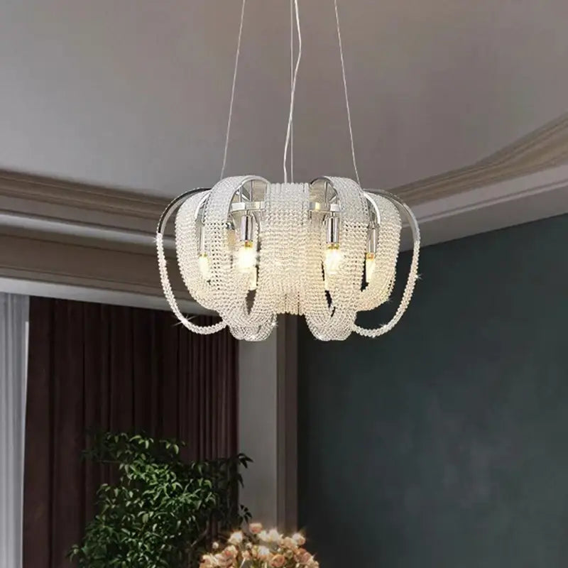 A modern multi-tiered decorbites crystal chandelier with sleek chrome frame and clear crystal beads for luxury lighting
