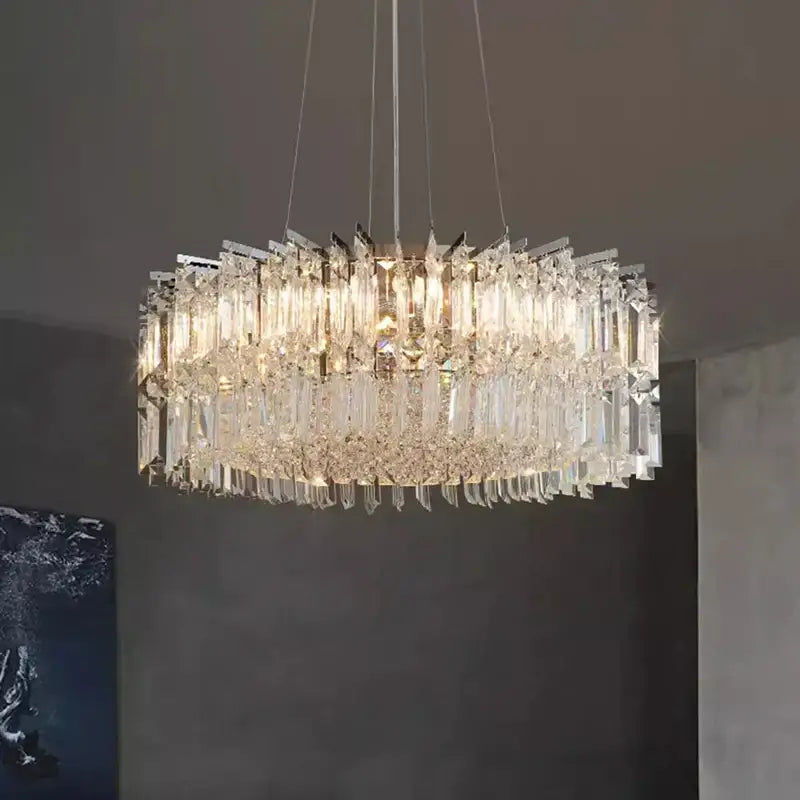 A modern decorbites crystal chandelier with cascading clear crystal prisms and a sleek metallic frame for luxury spaces