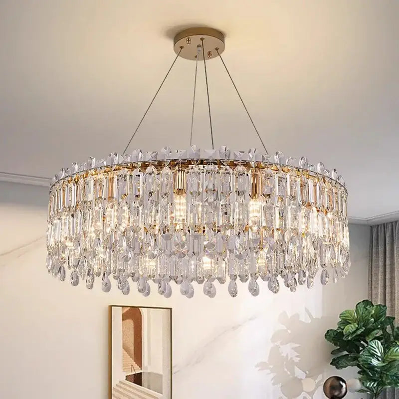 A modern circular decorbites crystal chandelier with cascading clear crystal prisms and gold-toned metal accents
