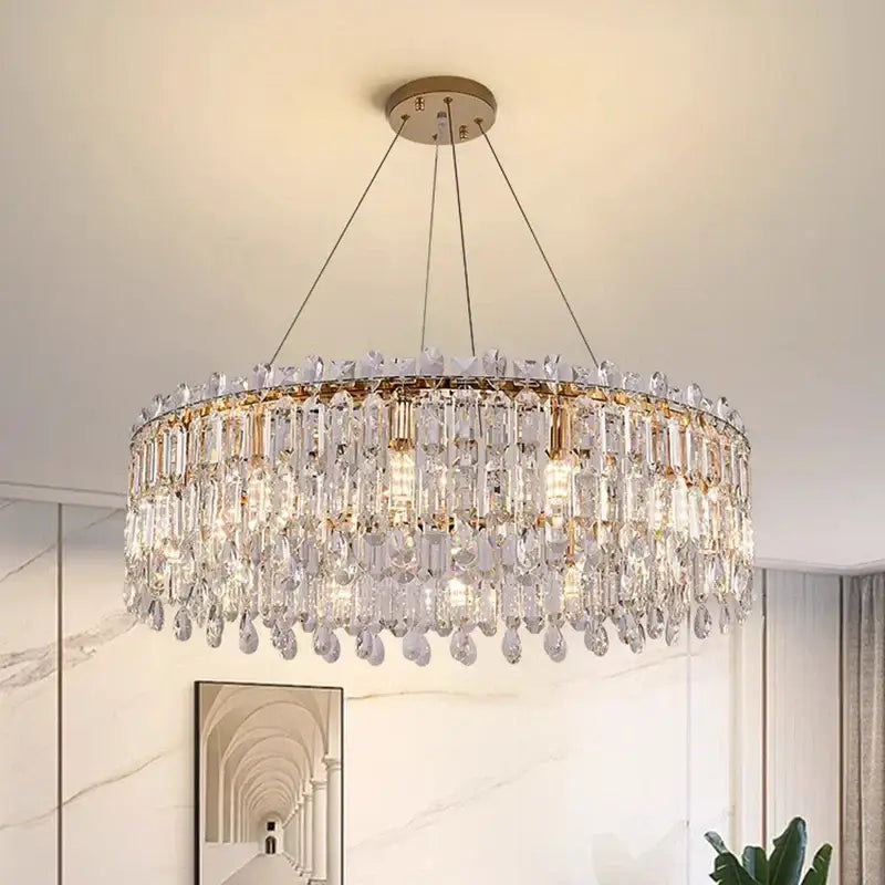 A decorbites crystal chandelier with clear crystal droplets and rectangular prisms on a gold frame for living rooms