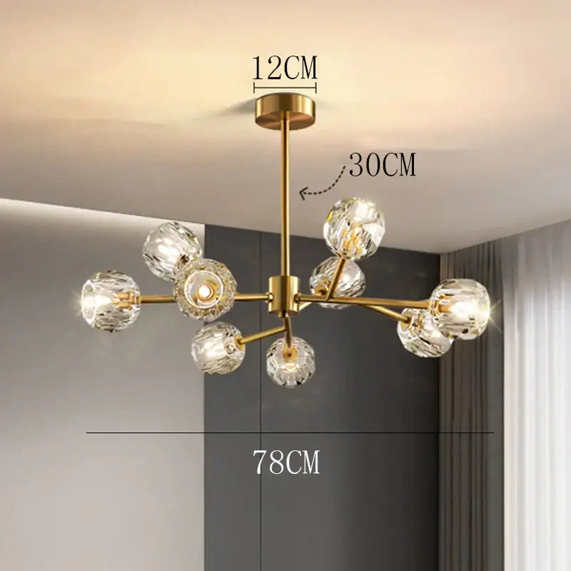 Gold-toned decorbites crystal chandelier with crystal globe bulbs and central brass stem for luxury living room lighting