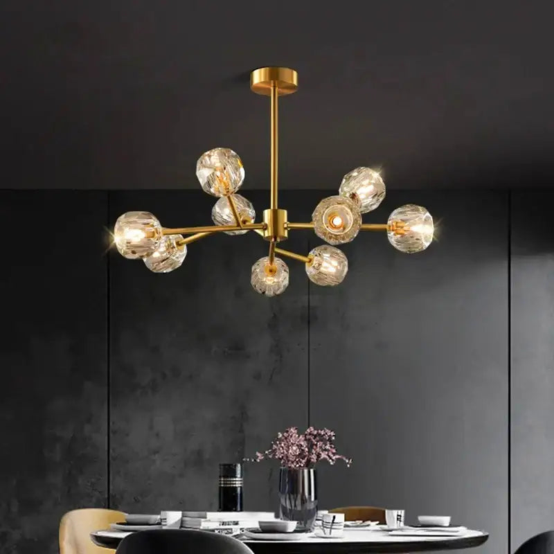 Gold-toned decorbites crystal chandelier with multiple faceted crystal globe bulbs for luxury living and dining rooms