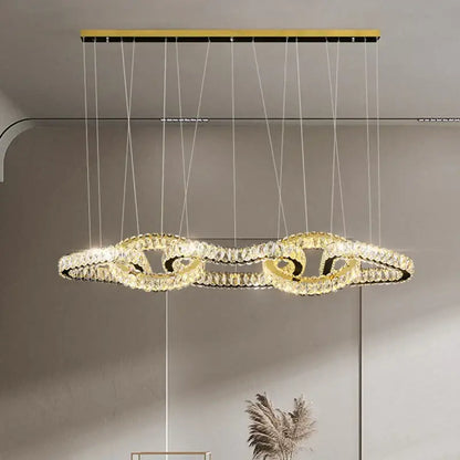 Gold-toned decorbites crystal chandelier with intertwined crystal rings for luxury living and dining room lighting