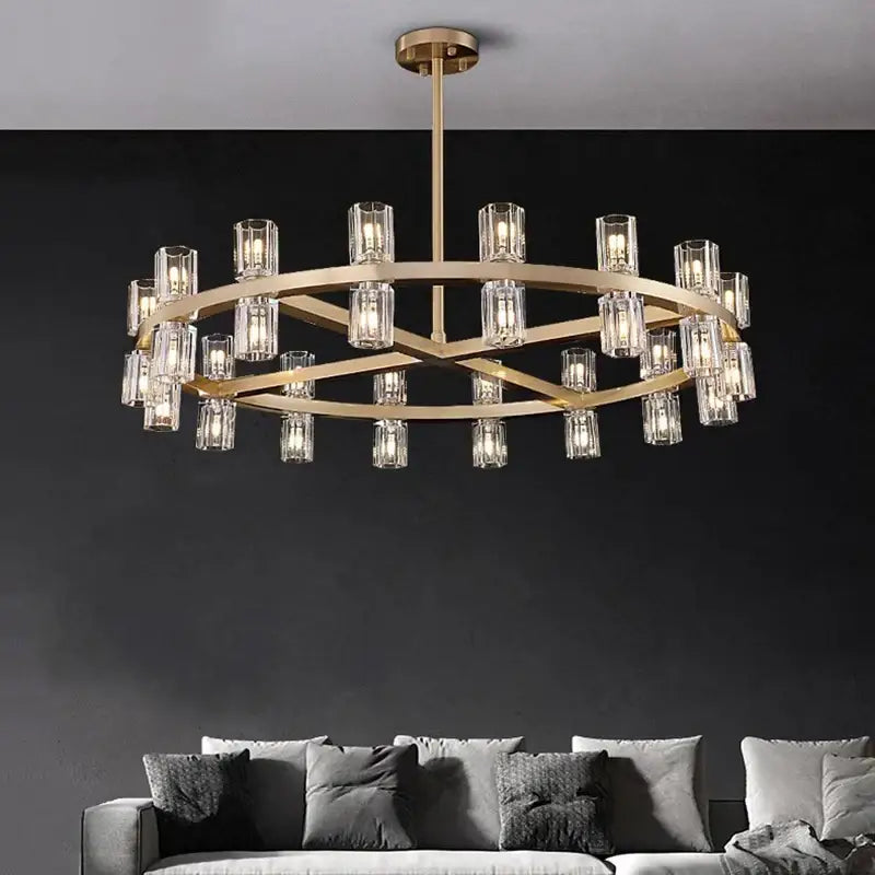 Gold-toned decorbites crystal chandelier with clear glass cylindrical shades in a circular layered design for luxury rooms