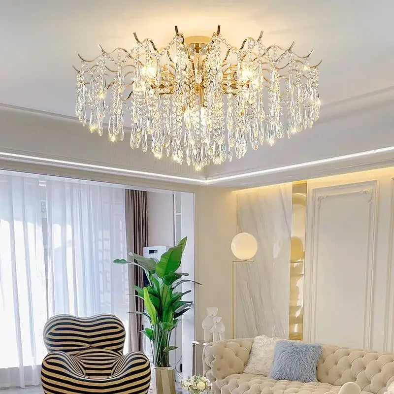 A luxury decorbites crystal chandelier in gold tone with intricate arms and cascading crystal droplets for living rooms