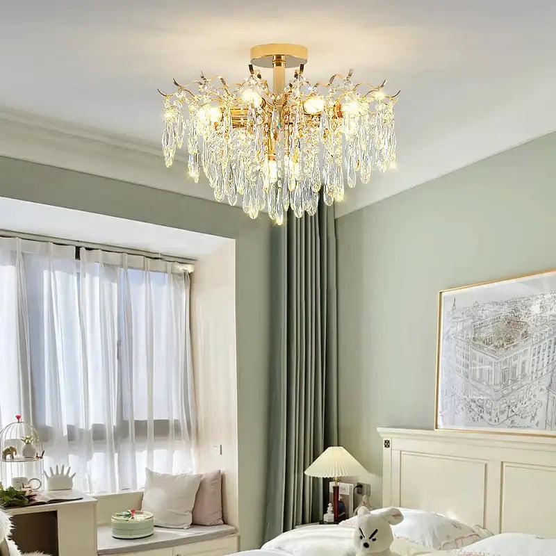 Gold-toned decorbites crystal chandelier with cascading crystal droplets and warm glowing bulbs for elegant living space lighting