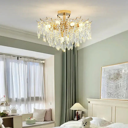 Gold-toned decorbites crystal chandelier with cascading crystal droplets and warm glowing bulbs for elegant living space lighting