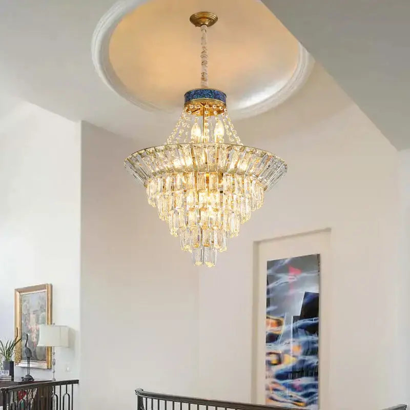 A decorbites crystal chandelier with gold metal accents and a blue mosaic ring for luxury living room lighting