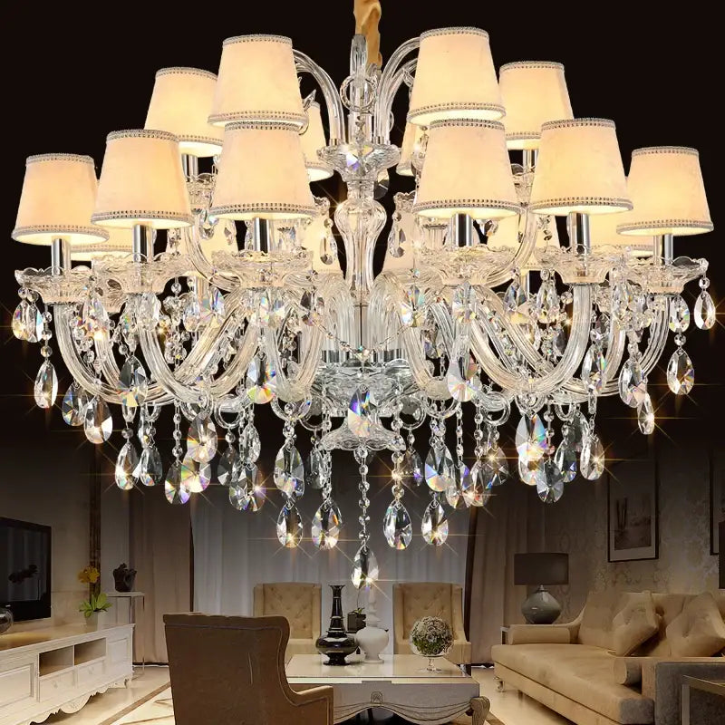 DecorBites crystal chandelier with multiple tiers of clear faceted glass droplets and cream lampshades for living room