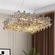 A modern rectangular decorbites crystal chandelier with clear and gold-toned prisms for living and dining rooms