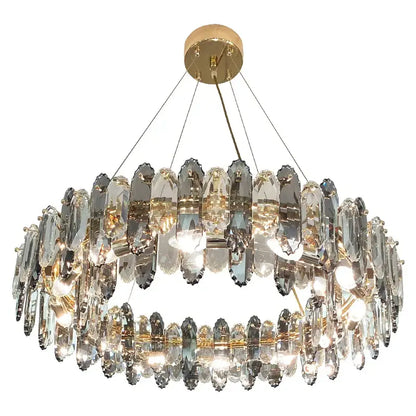 A two-tiered decorbites crystal chandelier with clear faceted crystals and gold-toned mount for living and dining rooms