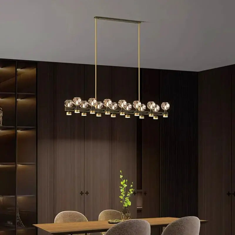 Modern brass-finished decorbites crystal chandelier featuring faceted crystal spheres for living and dining rooms