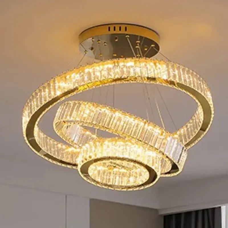 Gold-toned decorbites crystal chandelier with three interlocking rings featuring faceted crystals for luxury lighting