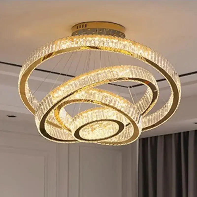 Gold-toned decorbites crystal chandelier with three interlocking circular rings for luxury living room lighting