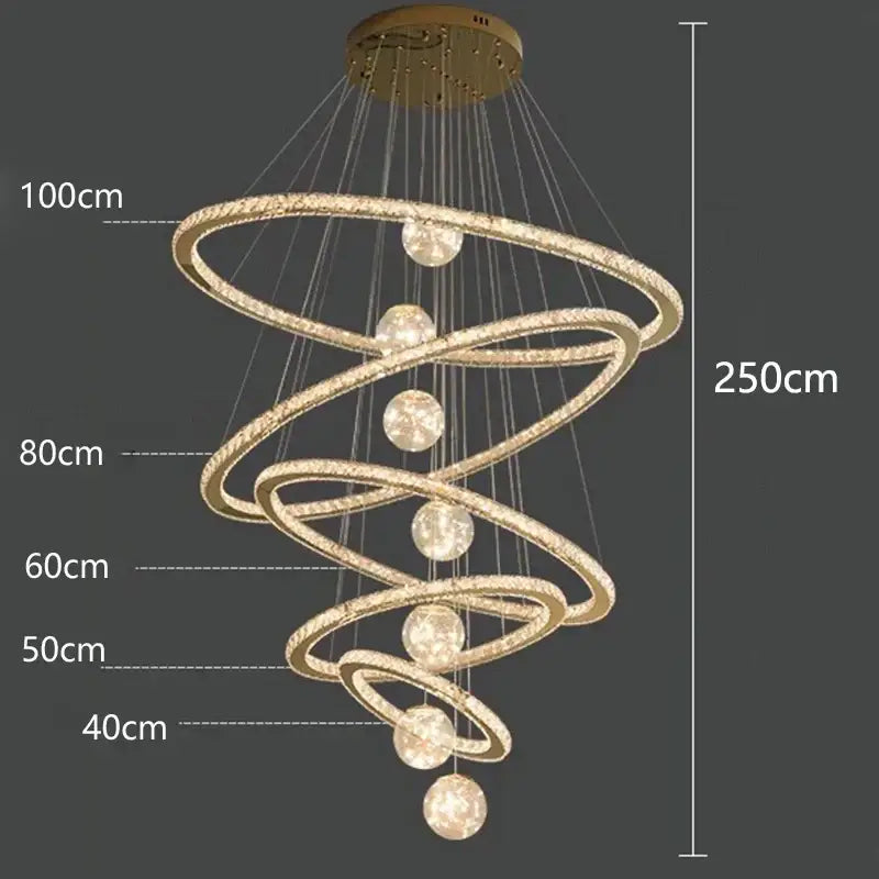 Gold-toned decorbites crystal chandelier with glowing spherical lights suspended between interlocking rings for indoor lighting